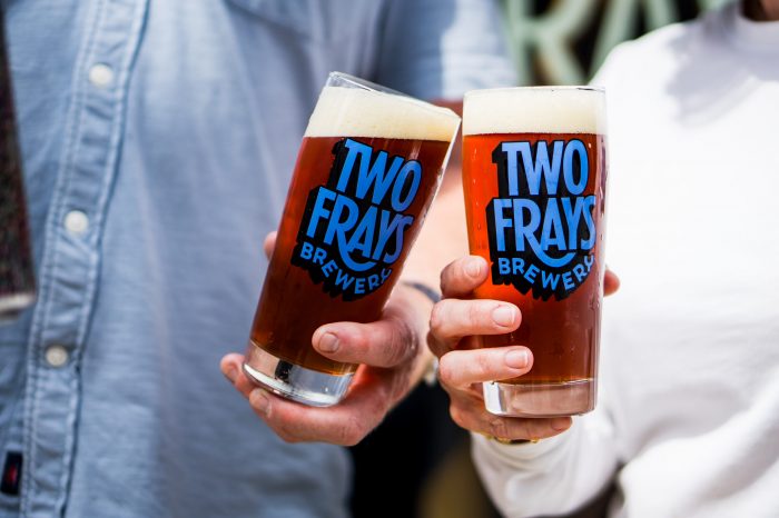 Couple holding glasses of Two Frays brewery beer